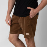 Person wearing brown shorts with a visible onda logo on a white background