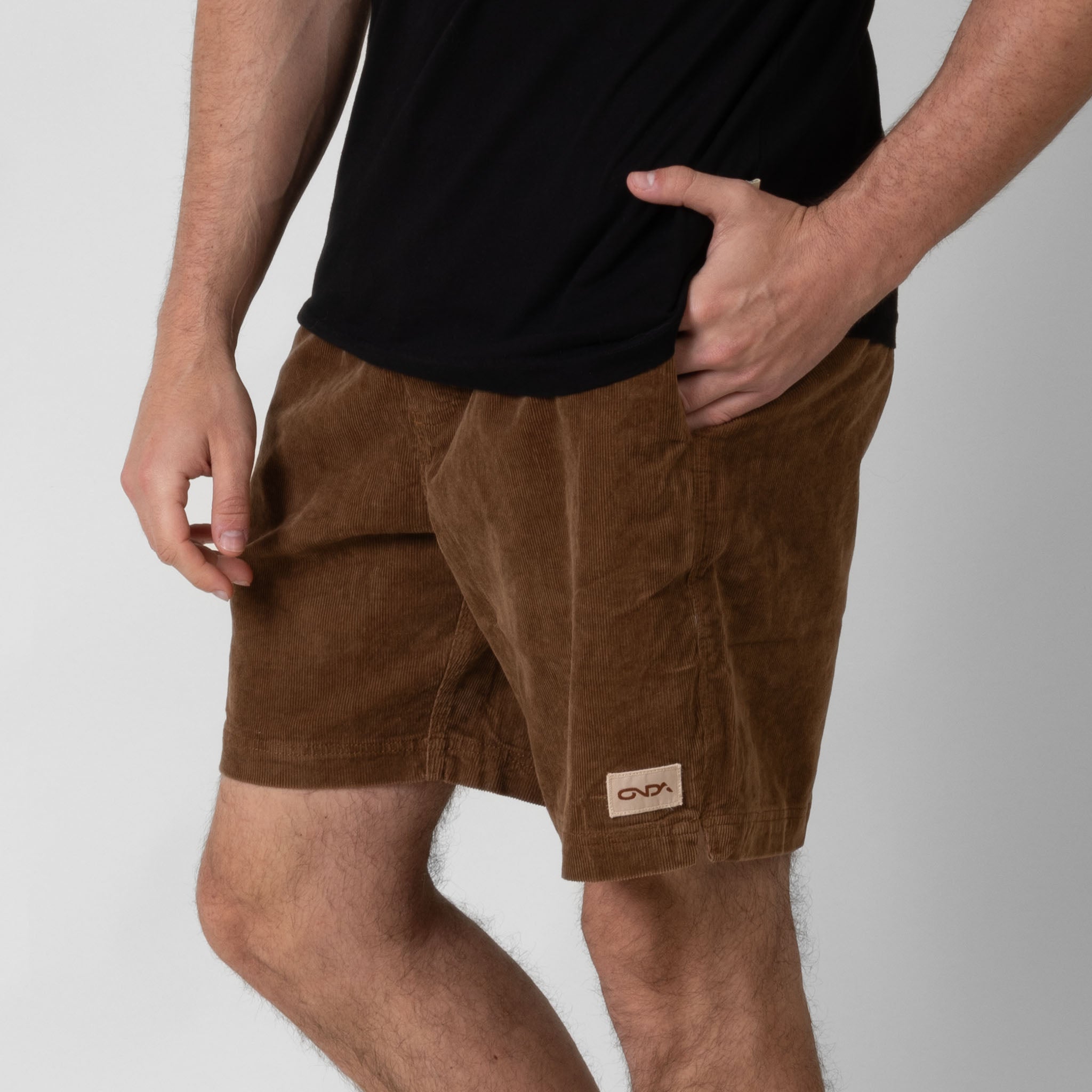Person wearing brown shorts with a visible onda logo on a white background