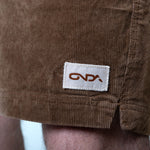 Close-up of brown corduroy shorts with an onda label on the pocket.