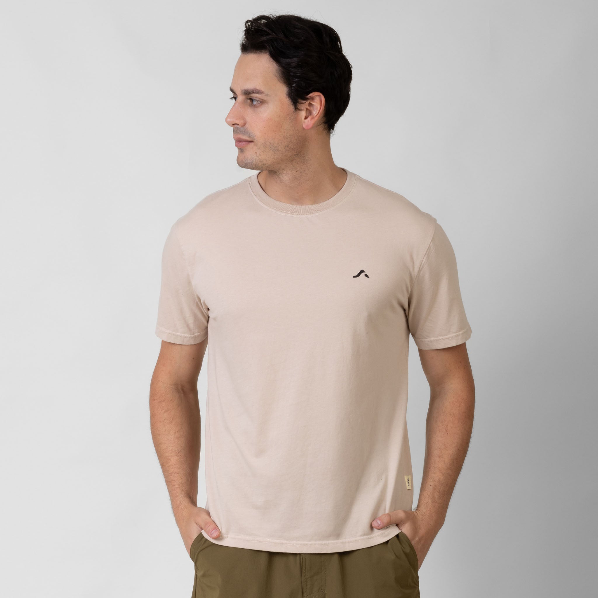 Man wearing a beige t-shirt with a small black onda logo on a white background