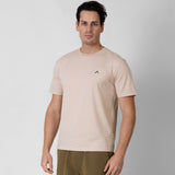 Man wearing a beige t-shirt with a small black onda logo on a white background