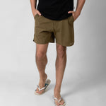 Person wearing brown shorts on a white background