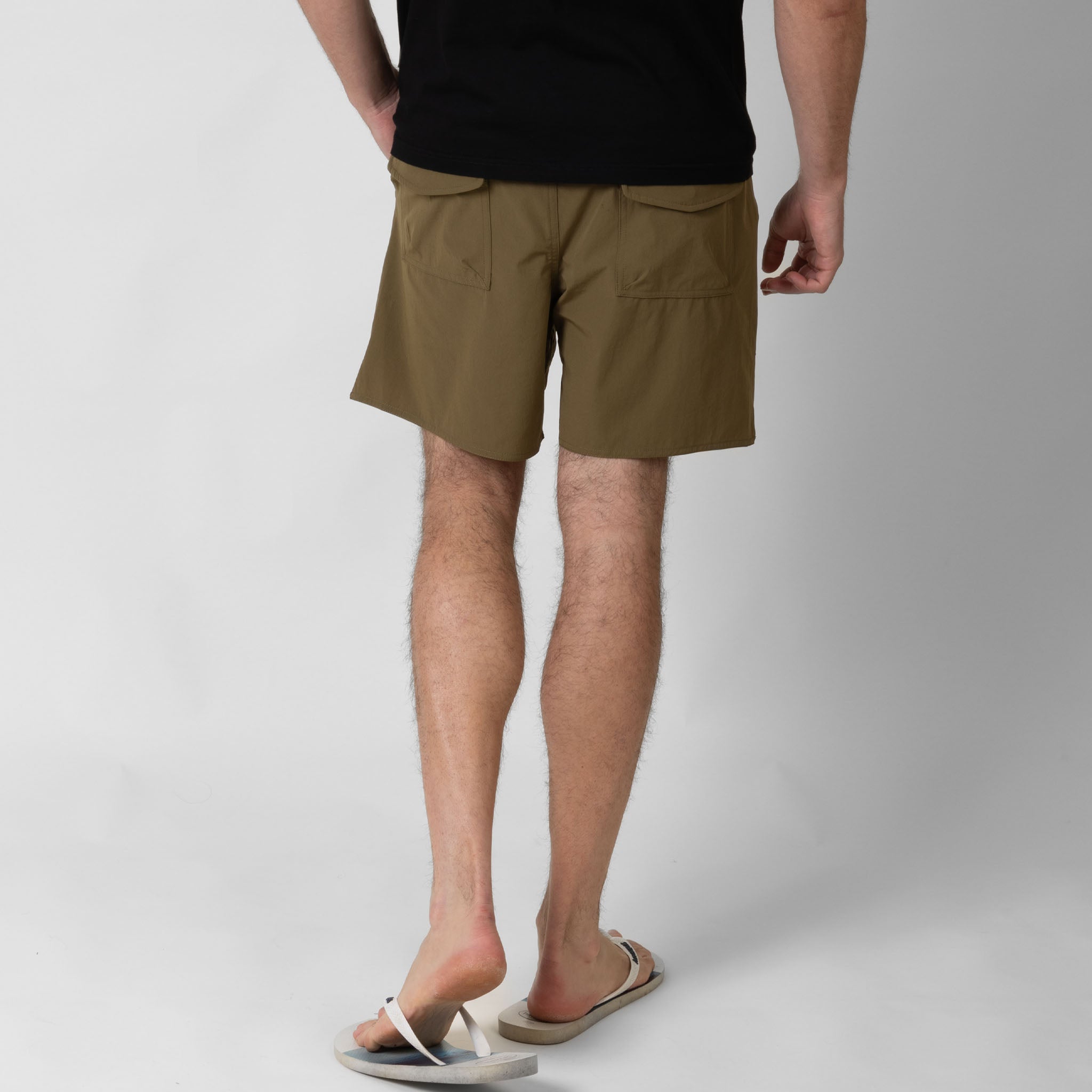 Person wearing brown shorts on a white  background