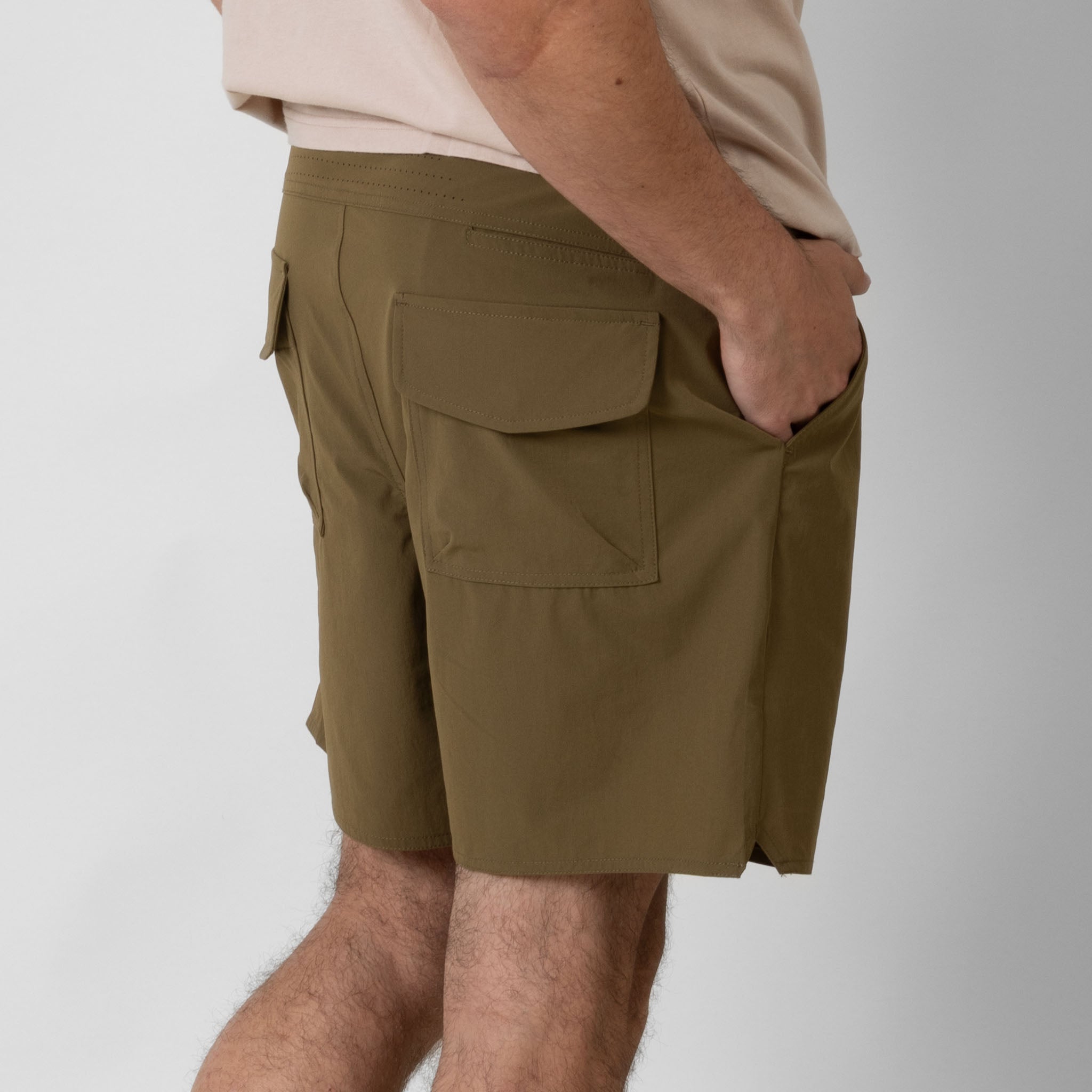 Person wearing brown cargo shorts on a white background