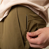 Person wearing brown shorts with a beige shirt, focusing on the shorts.