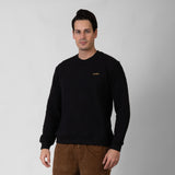 Man wearing a black sweater with a onda logo on a gray background