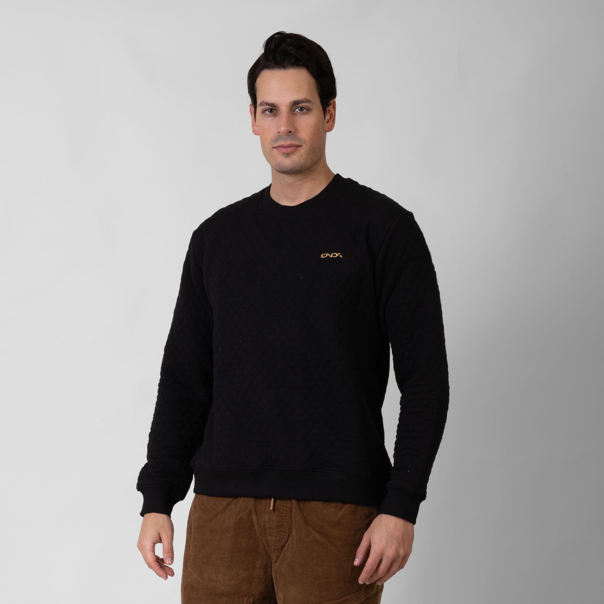 Man wearing a black sweater with a onda logo on a gray background