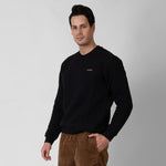 Man wearing a black sweater with a onda logo on a gray background