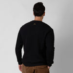 Person wearing a black sweater with a onda logo on the back against a gray background