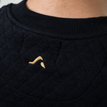 Black textured garment with a small embroidered onda logo on a plain background