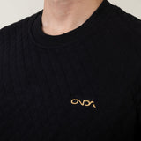 Black sweater with a gold onda logo on a neutral background