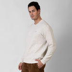 Man wearing a textured white sweater against a white background