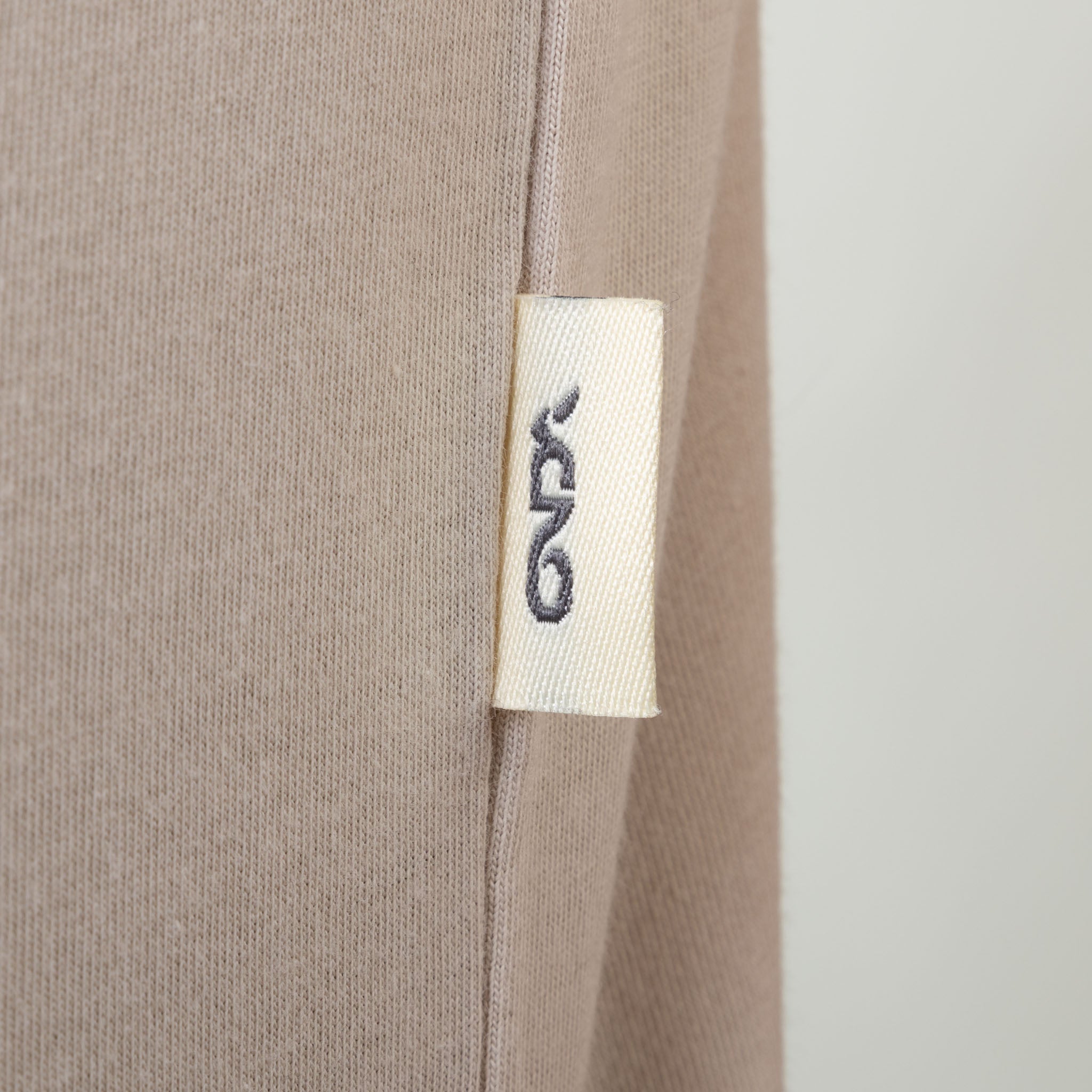 Close-up of a beige fabric with a onda label on a white background