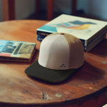 Baseball cap on a wooden table with books in the background